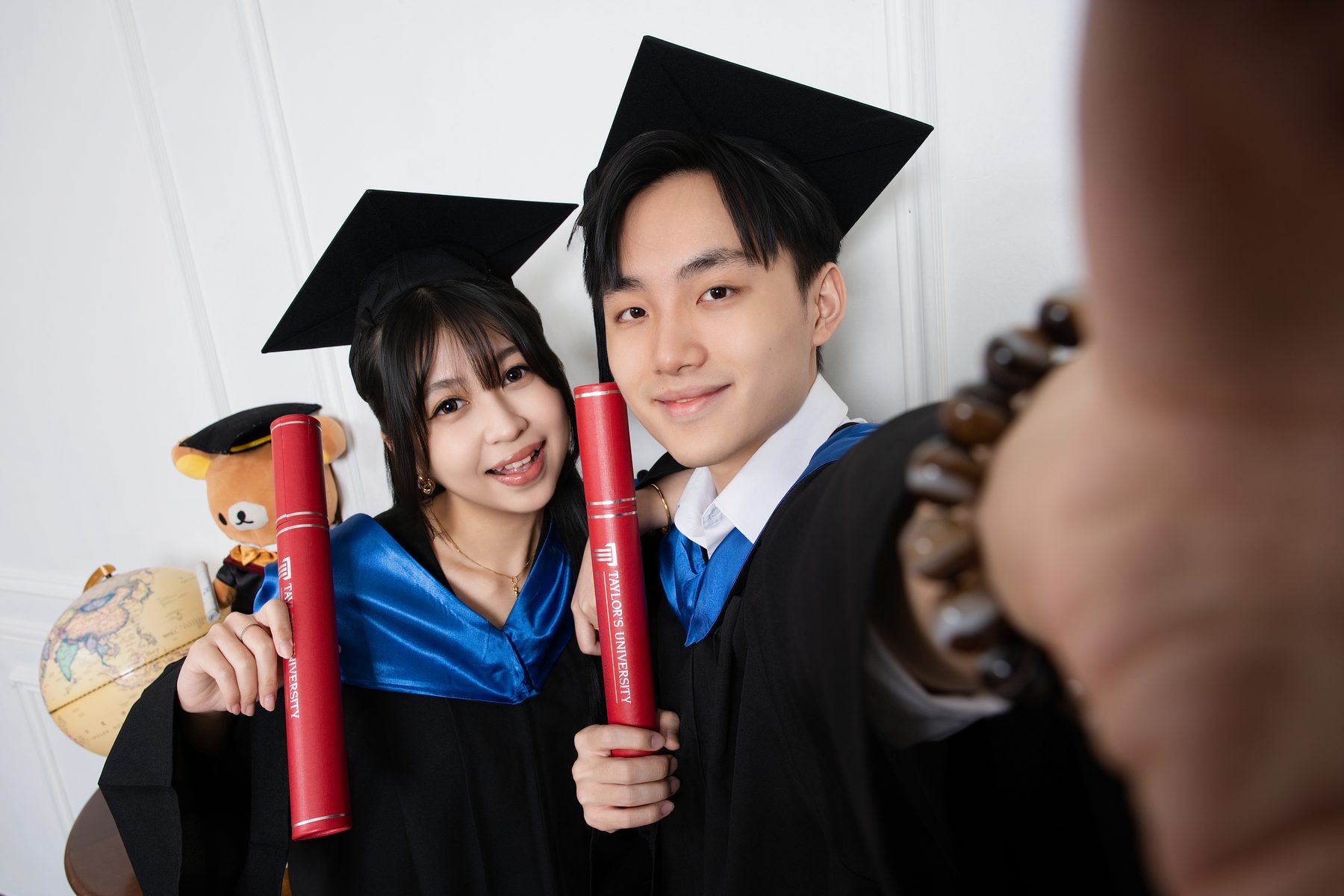 Premo Studio real client graduation photo — solo graduate portrait with scroll